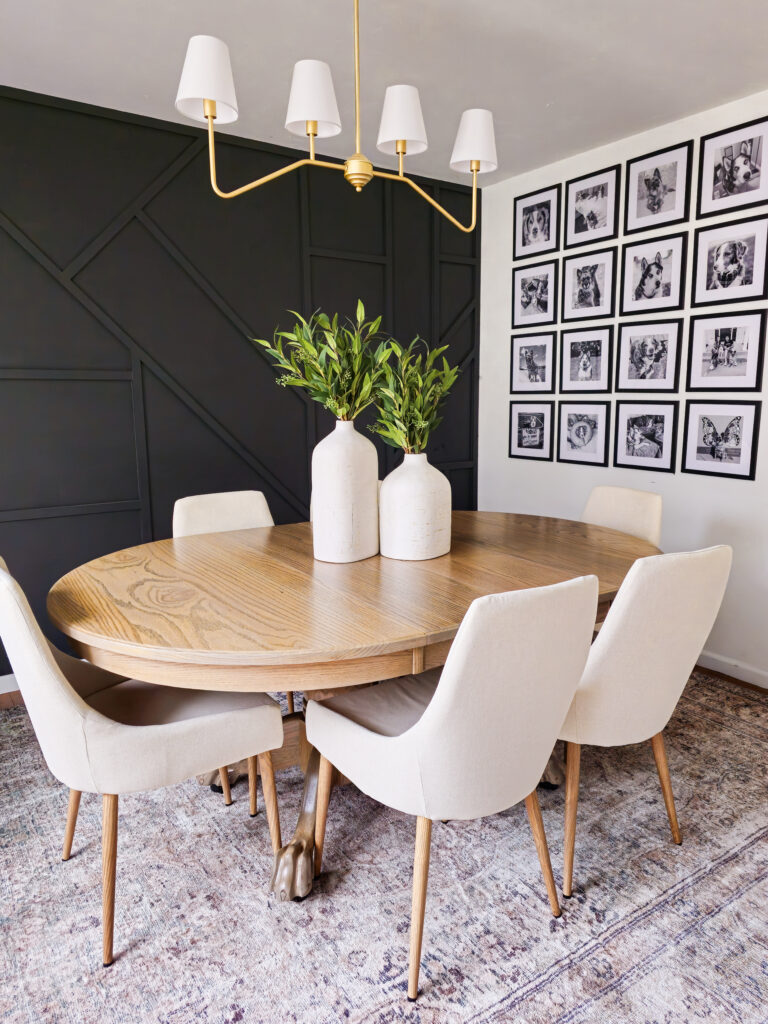 Geometric Accent Wall in the color Black using 1x2 boards. Oak Table with lion claw feet and linen chairs. Gold Light fixture with white lampshades. Gallery Wall with 12x12 frames filled with pictures of dogs