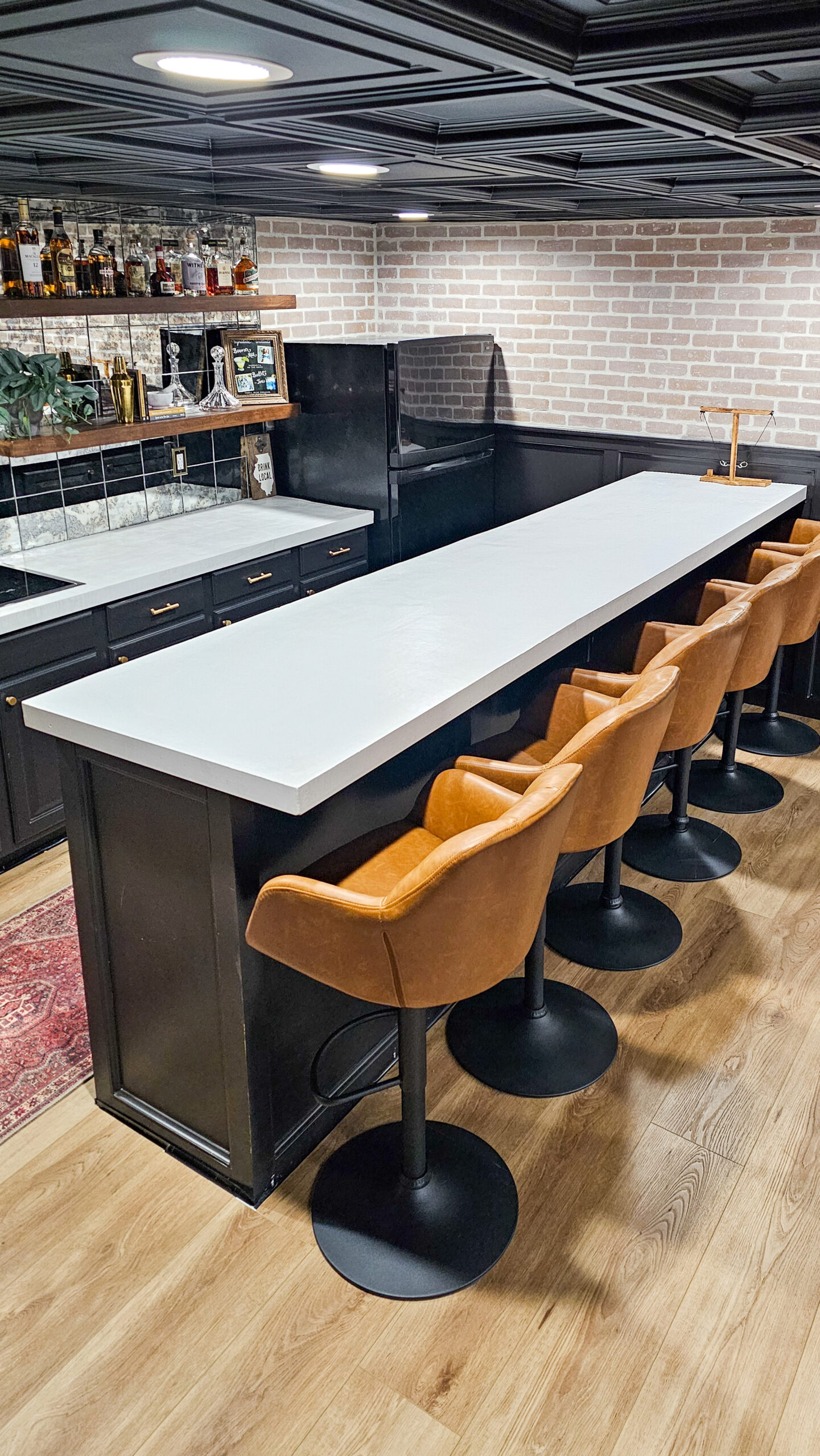 black bar with concrete countertops and cognac chairs